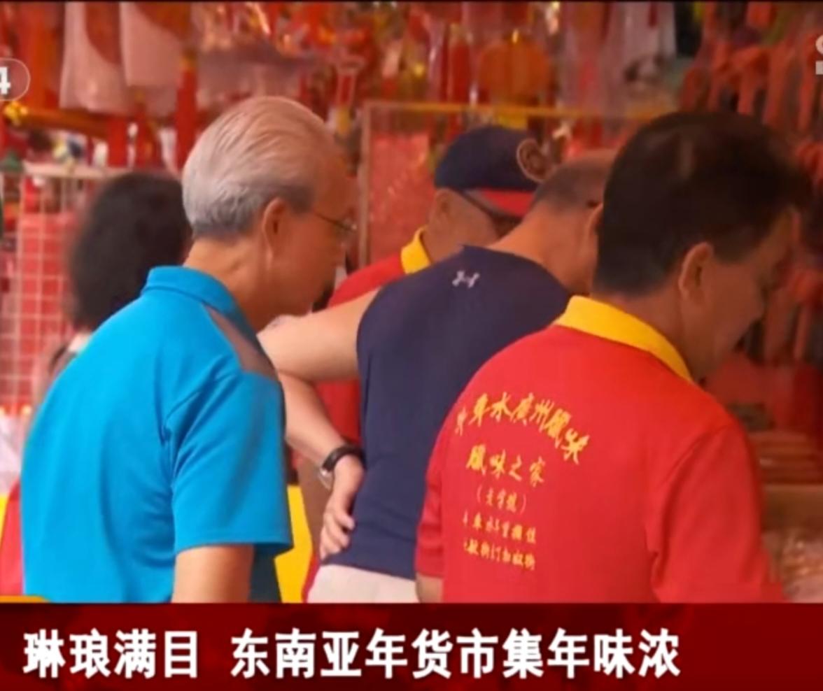 红灯笼高挂成海，把市集的天空染得通红。摊前挤满了挑选年货的人，老人细细摆弄着红绸