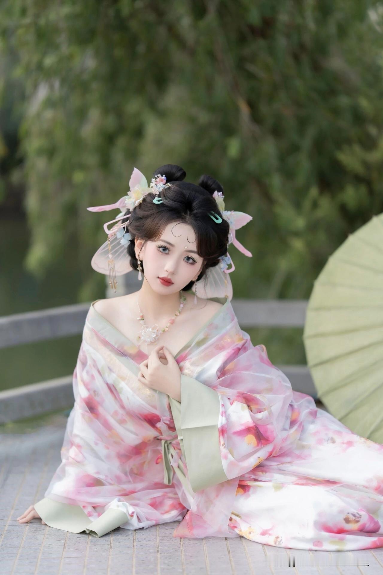 像是从山水画里走出的仙子。
身畔是碧波荡漾的江水，
身后是连绵起伏的青山。
不需