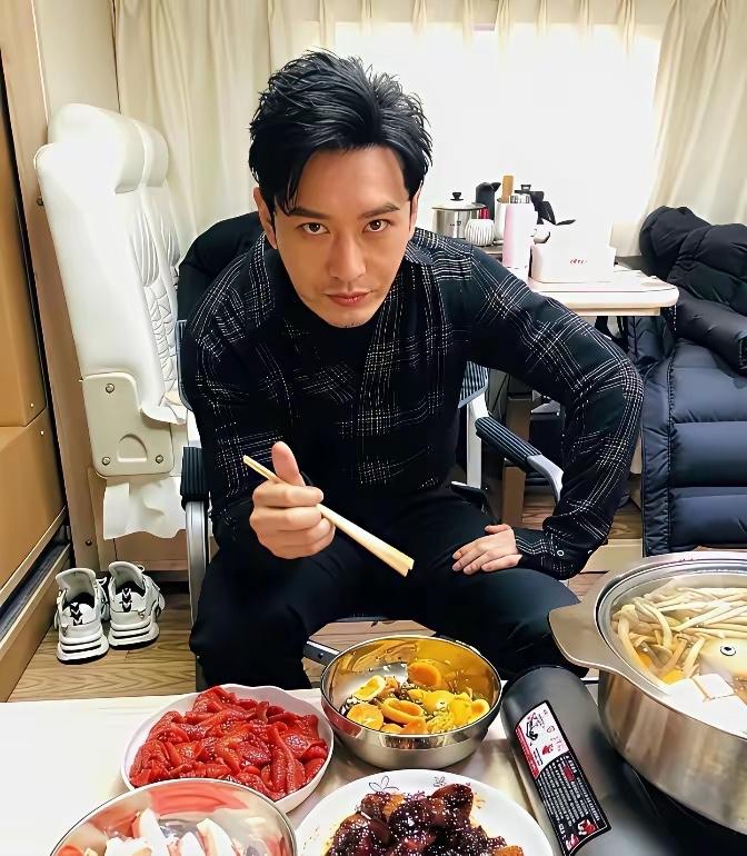 黄晓明的旧照，他坐在那里吃火锅，空间有点小，桌子也比较低，但他很帅气，哈哈。黄晓