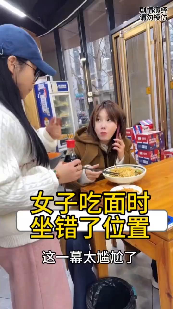 女子和朋友一起吃面，坐错了位置。
女子和朋友一起吃面，这时她告诉朋友这家小菜也很