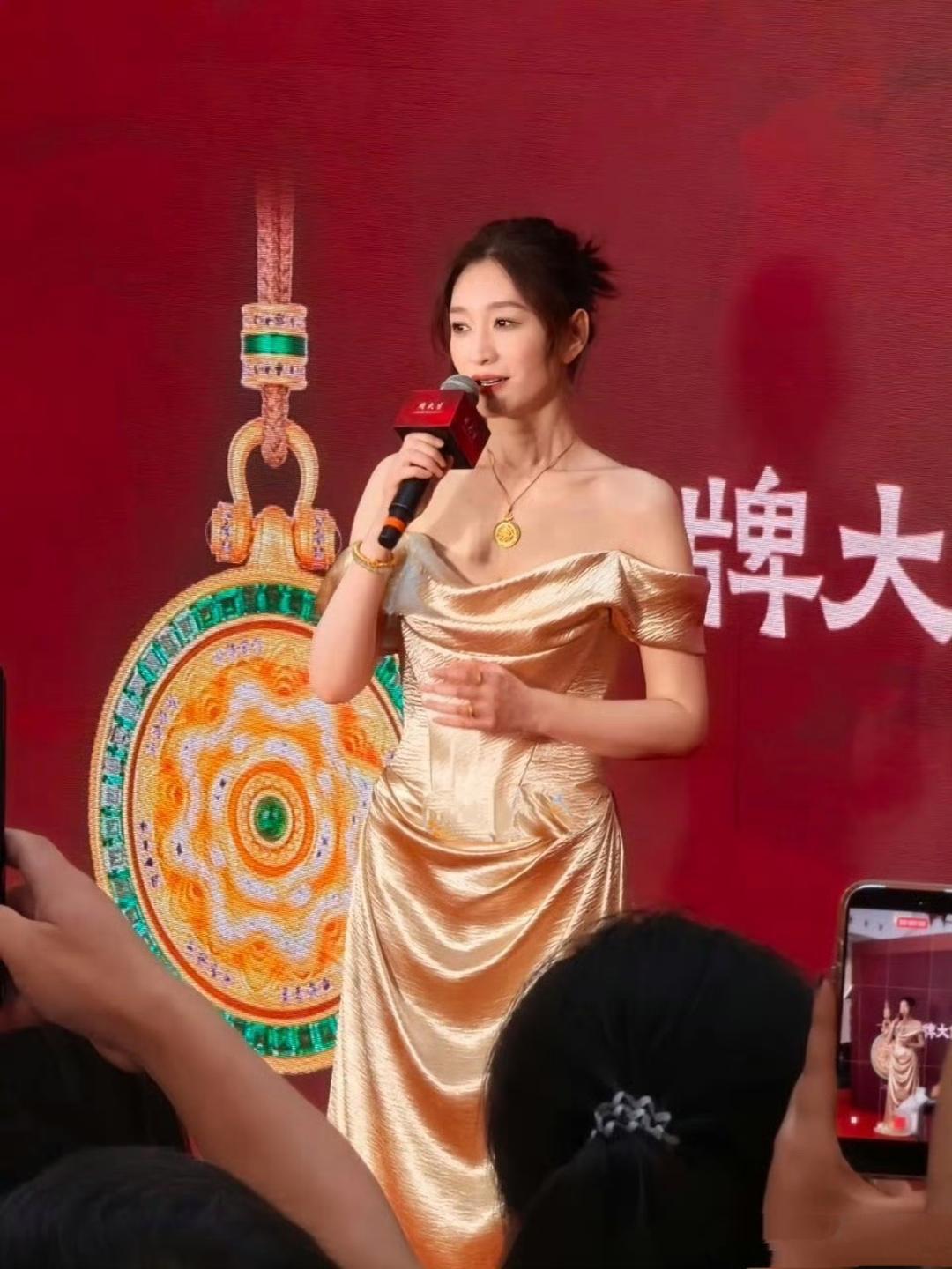 李小冉现身南通万象城，参加线下品牌活动，她一身丝绸锦缎露肩晚礼服，扎着丸子头，皮
