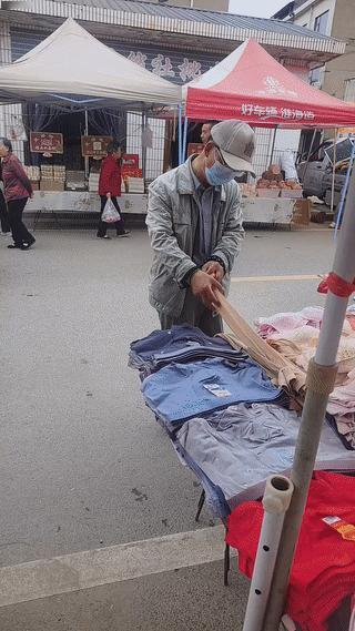 一名男子在街头一个服装摊上反复徘徊，犹豫挑选了大半天？
他最后终于鼓起勇气小心翼