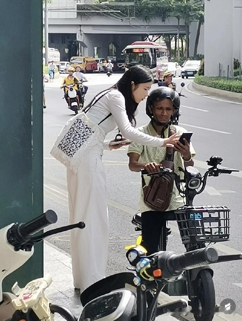 三元里现状，这个美女也真是单纯！
 
在三元里街头，穿白裙的美女弯腰给骑电动车的