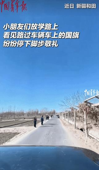 泪目！新疆和田，一男子正在路上开车，这时，一群放学的小朋友纷纷停下脚步对着他这边