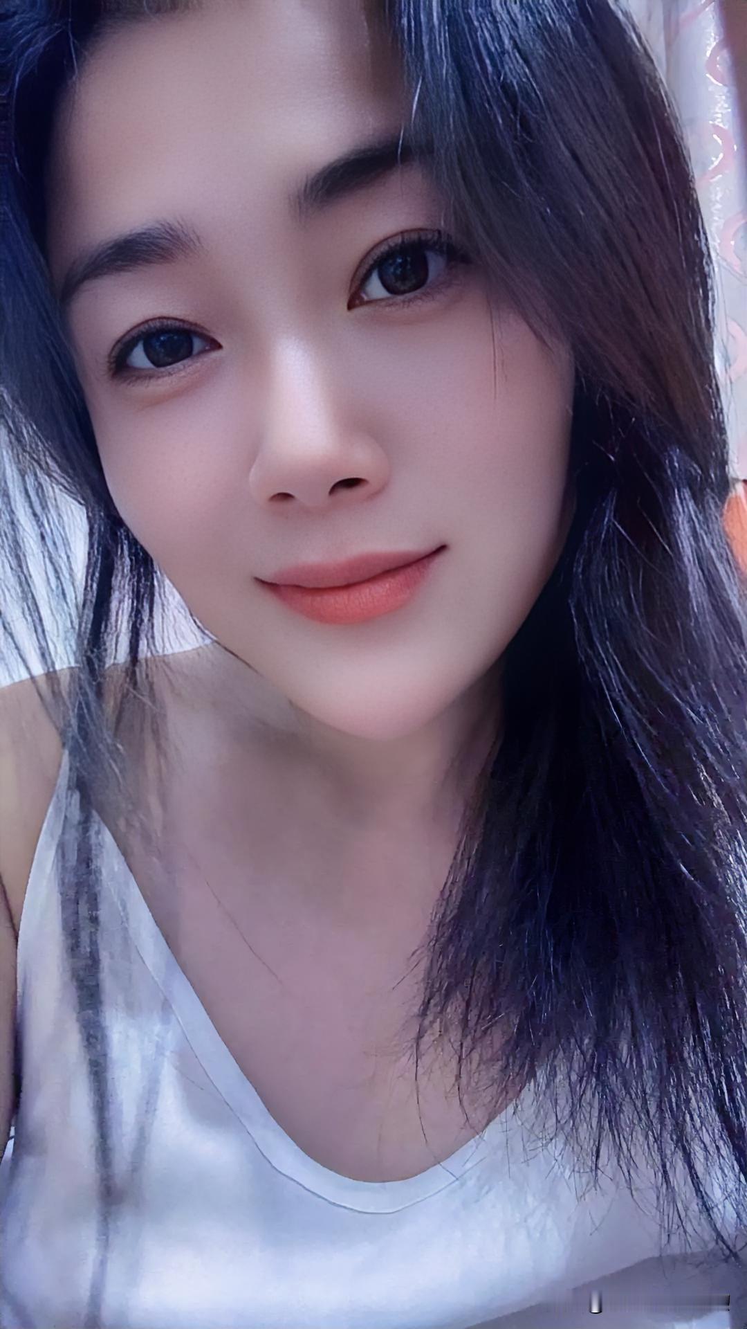 墨发如瀑垂肩，眸若星子澄澈，唇染朝霞暖色。白衣胜雪，衬得肌肤若凝脂，一笑间，春意