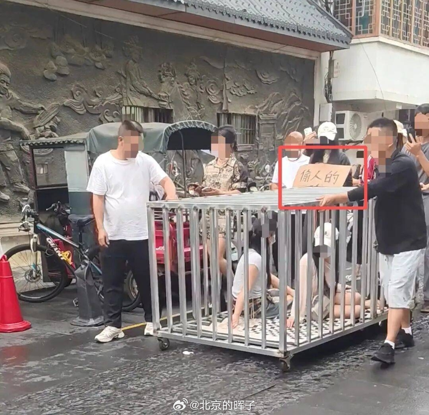 湖南两女子和狗被关笼中游街也不哭也不闹也不求救，就静静戴好口罩帽子笼子里面坐着，
