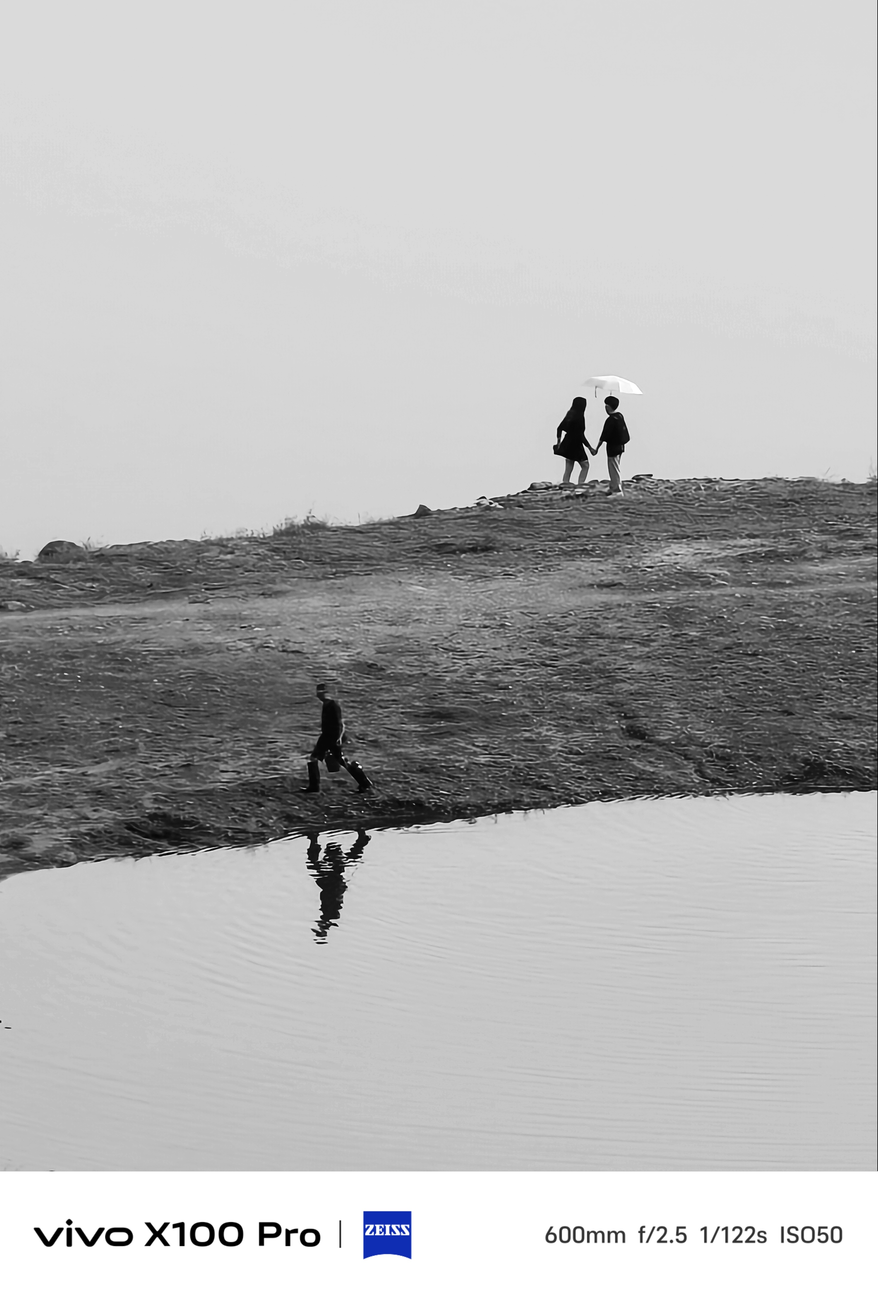 情侣与钓鱼人在广阔的天地间，携手同行的情侣与孤独的钓鱼人，静谧与陪伴在这里形成了