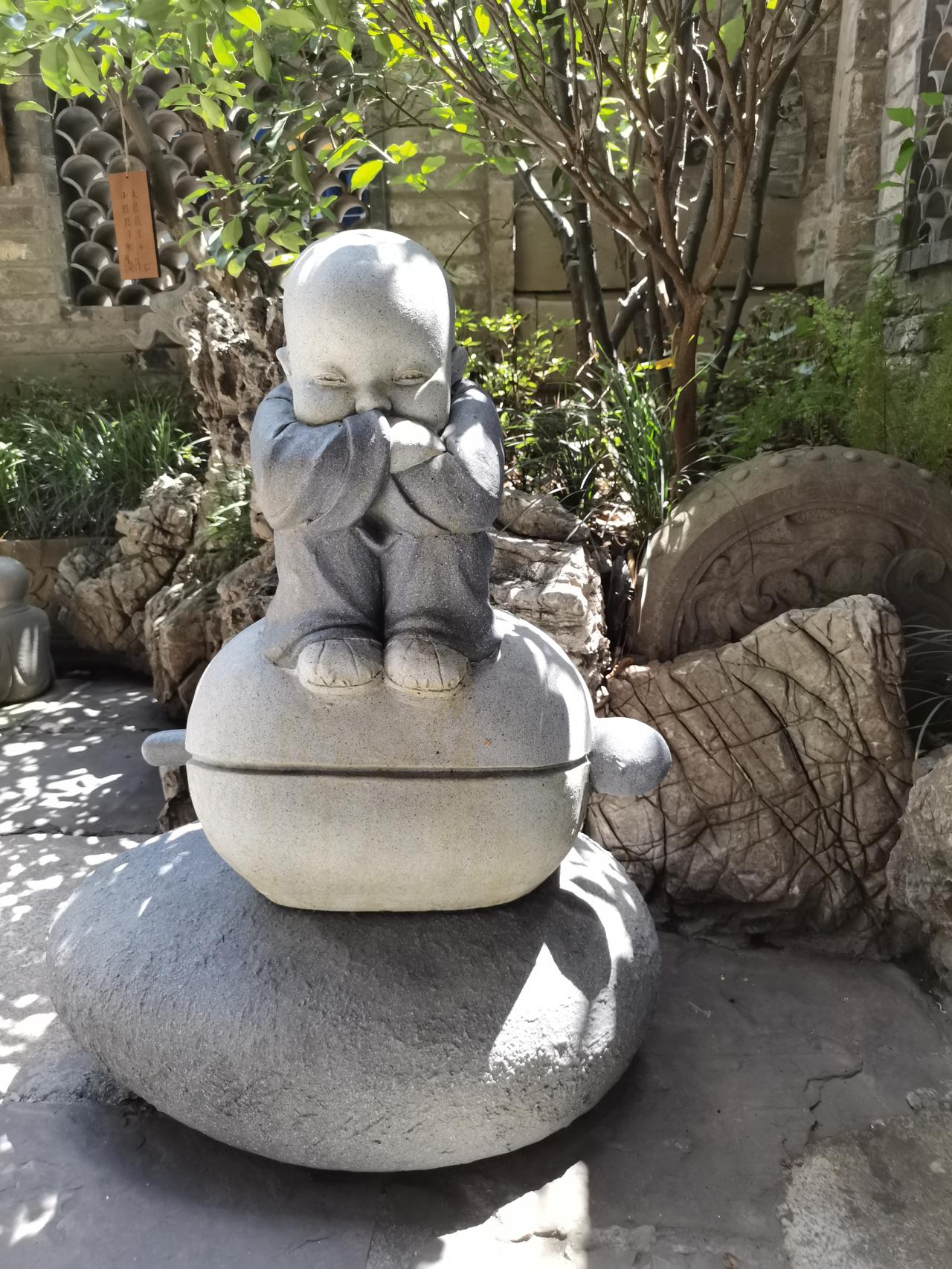 晒图笔记大赛蹲坐的小沙弥，掩口而笑，伫立在一个角落，有阳光来，打下光斑，给这个冬