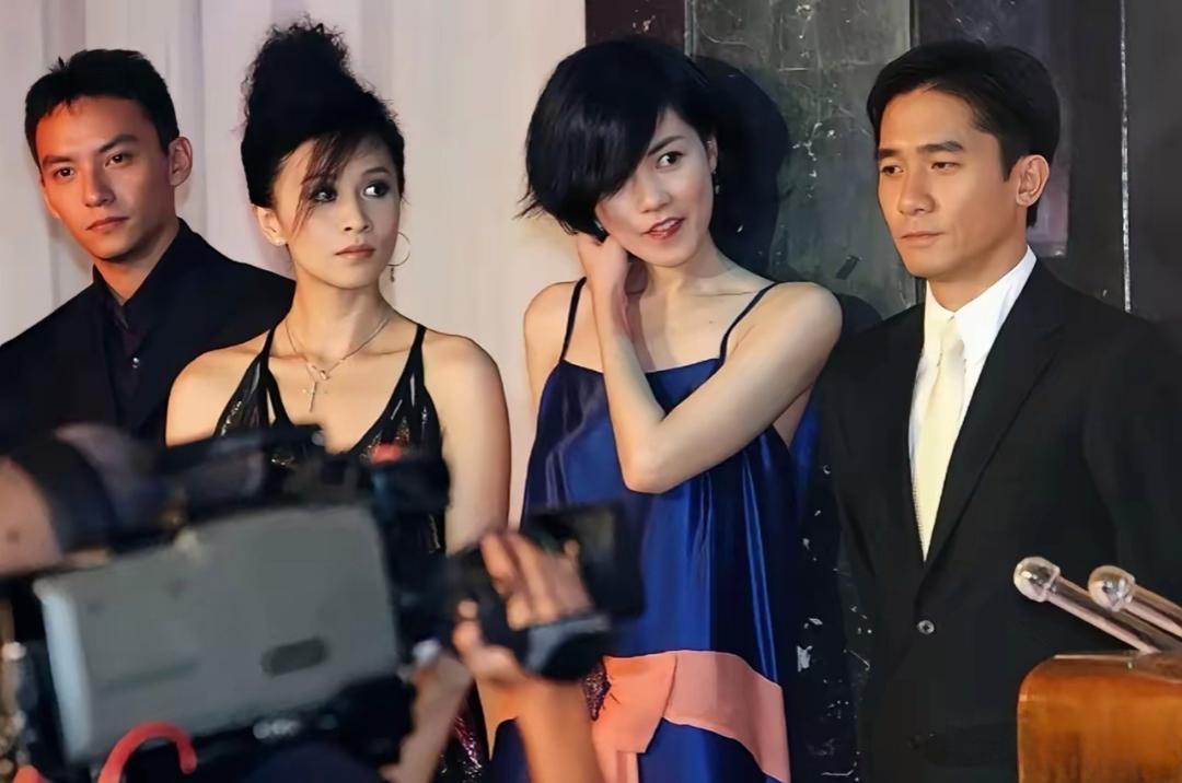 2004年，电影《2046》全球公映记者发布会，几位主演同框的画面。

导演王家