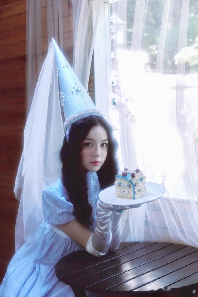 周也生日照像童话里的公主 被周也的生日造型美晕！尖顶帽配蓝裙子，背景的小洋楼和彩