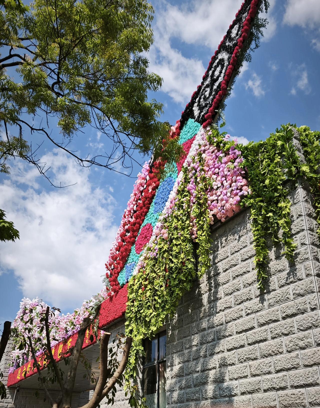 分享一下你随手拍下的照片把春天的色彩，都绣进这面花墙里。红与蓝交织成温柔的纹路，