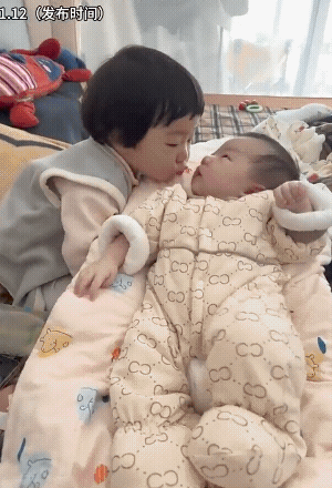 姐姐亲吻小宝宝，好似小宝宝有点不同意。结果，姐姐上了脚……
“敬酒不吃吃罚酒”，