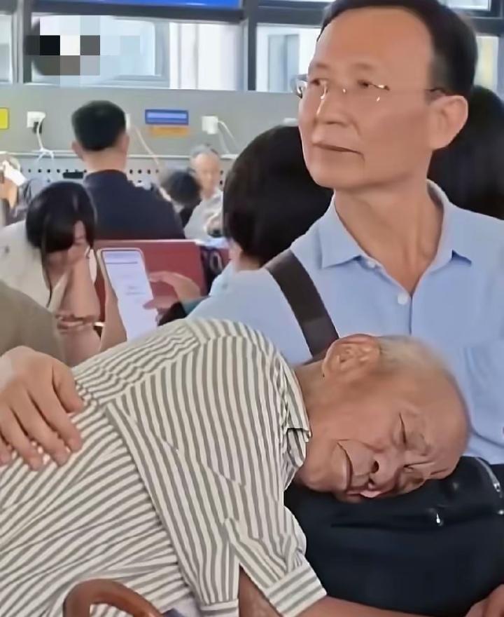 北京一机场候车厅随手拍下的一幕近日走红！大厅里，一位年迈父亲疲惫地趴在儿子怀中熟