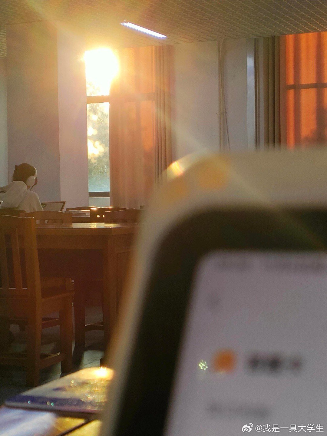 在图书馆抬头，看见阳光每天这个时候太阳正好快要落山，会有束束暖阳照向图书馆内，为