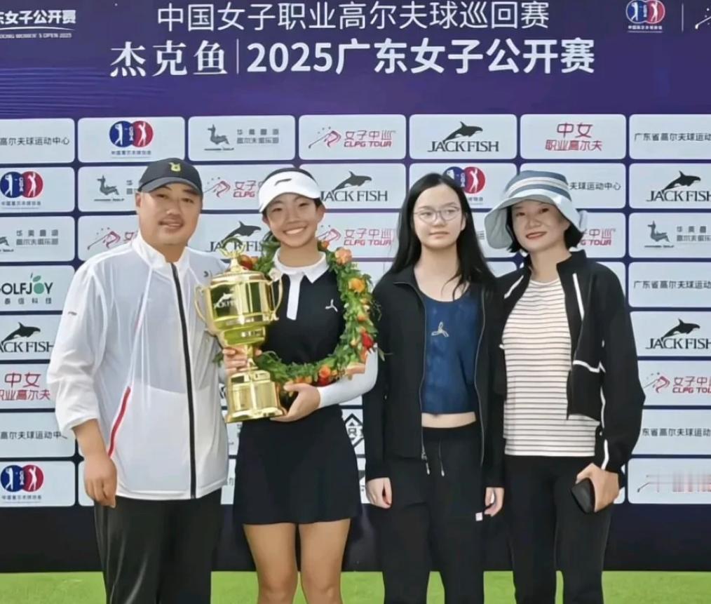 刘国梁女儿获得高尔夫球公开赛冠军后，一家四口站在台上合影，这次获奖的是他的大女儿