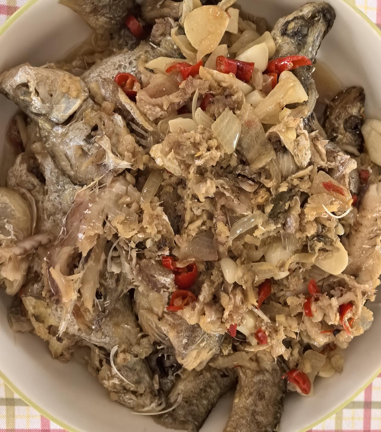 今日早餐简单又暖心。一盘鲜美的焖小鱼，蒜香浓郁，点缀少许红椒提味，肉质细嫩入味。