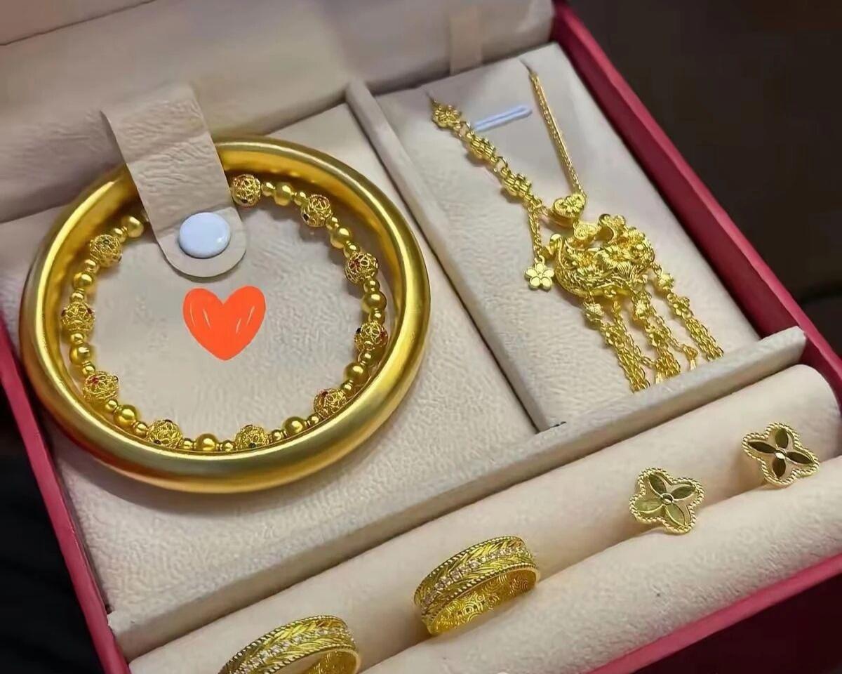 婆婆给了一套黄金首饰,红丝绒盒子装着有一个古法金镯子加一条金珠手链、一条凤凰流苏