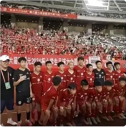 赢了比赛，庆功宴菜还没上桌，董路青训这帮孩子先掏出零食啃上了。

抱着礼物回座位