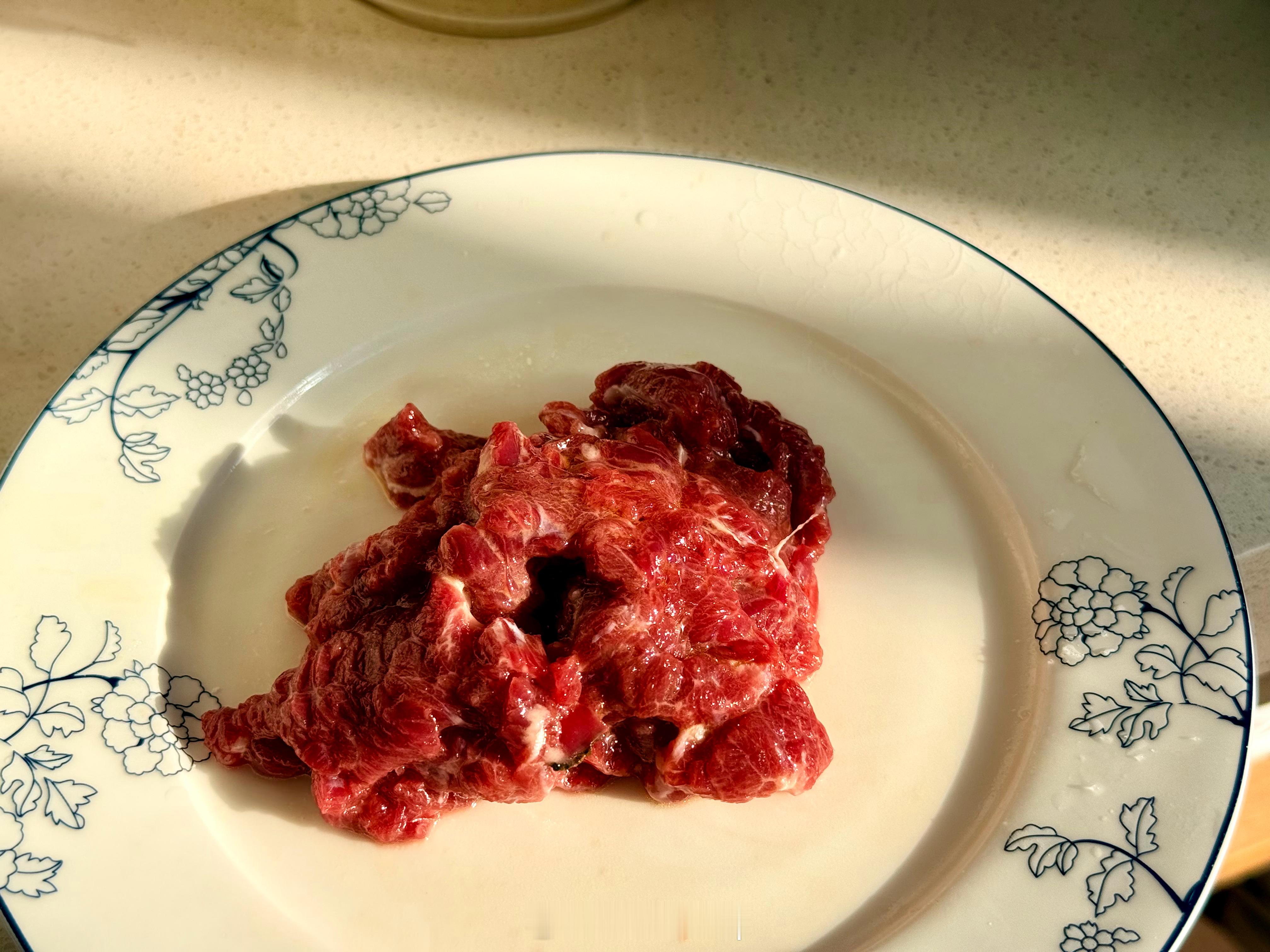 牛肉垂直纹路切薄片，加水，盐，白胡椒粉，抓起胶，加点淀粉抓匀，再拌点油进去锁水。