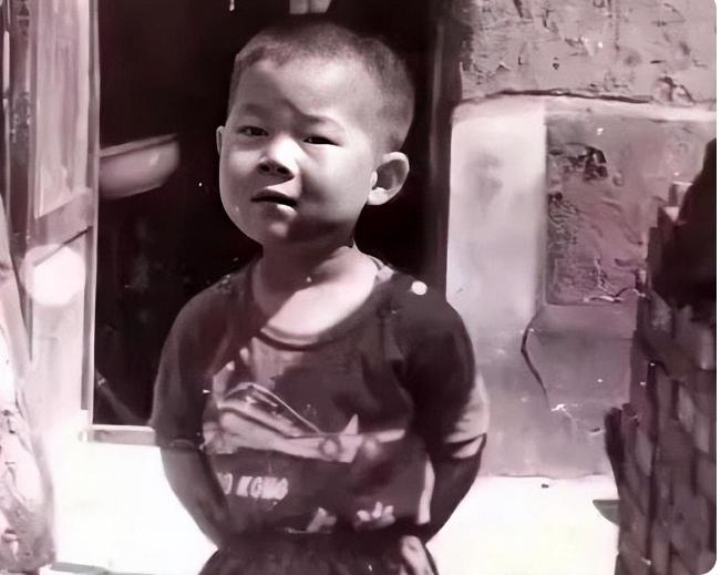 一张年代老照片，背着手的小男孩。谁能猜出来，这是谁的童年旧照？