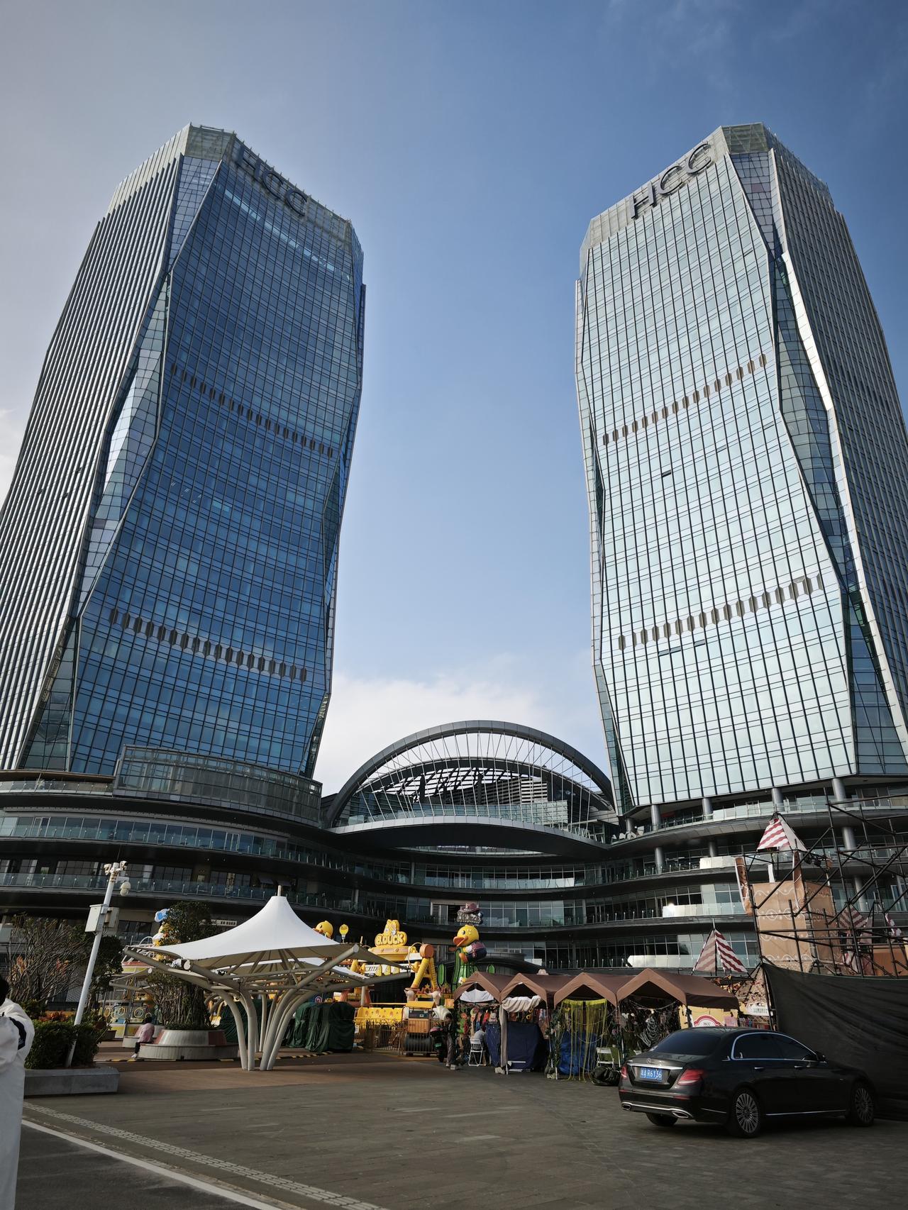 分享一下你随手拍下的照片在昆明双子塔的玻璃幕墙下，都市的摩登与街头的烟火撞了个满