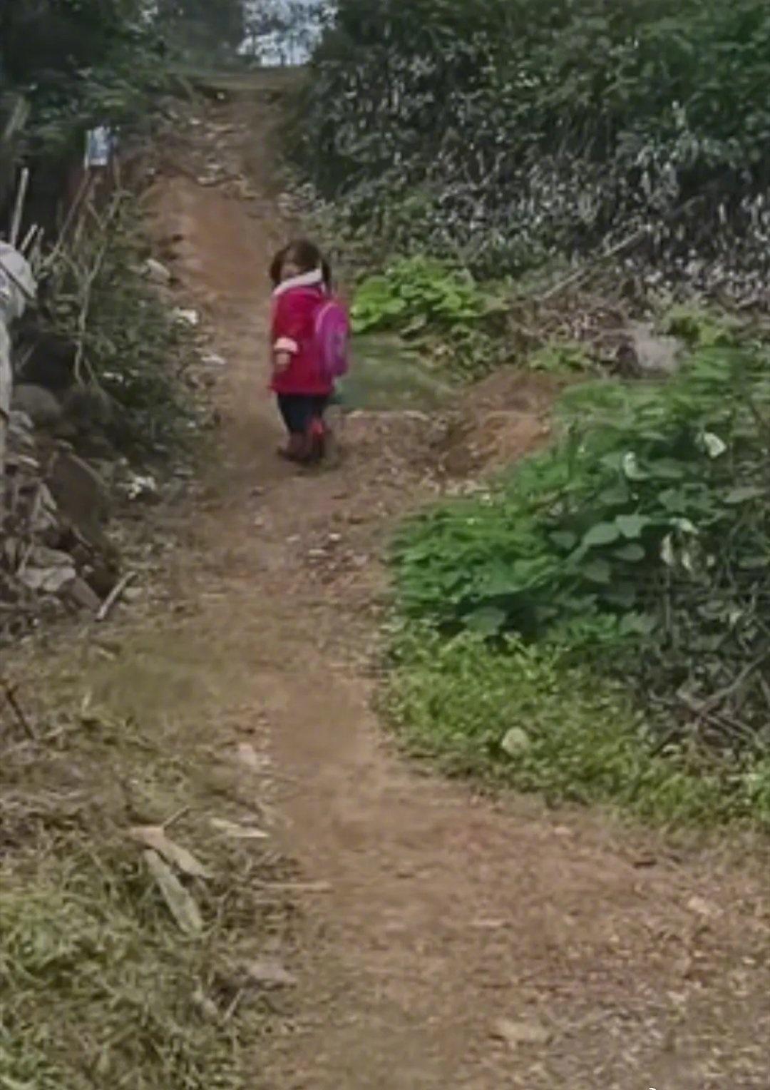 河南信阳一所乡村学校，放学后，一个小姑娘背着书包走上回家的土路。短短十多米的坡路