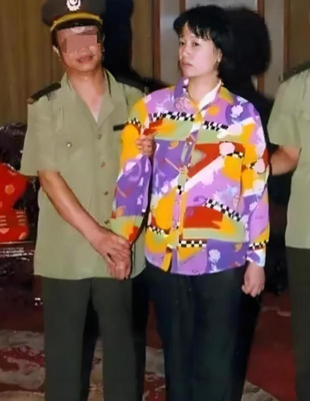 2000年，刘艺霞被判死刑，照片中的她，身穿花衬衫，被两名警察押送着，面无表情，