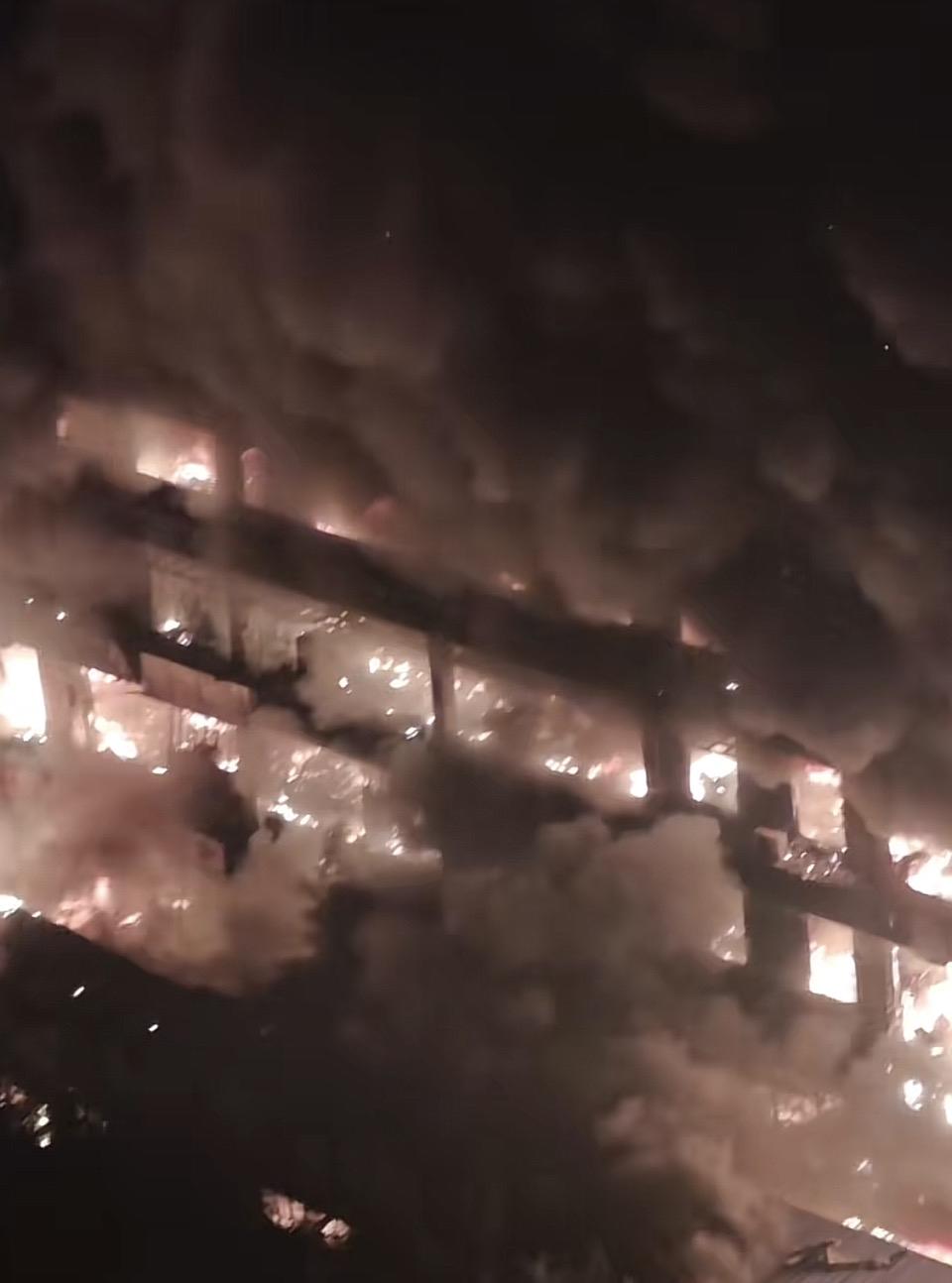 一栋大楼着火了，浓烟滚滚。深夜火灾，浓烟滚滚，紧急救援中