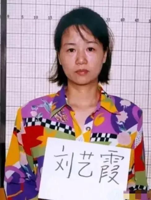 2000年，刘艺霞被判死刑，照片中的她，身穿花衬衫，被两名警察押送着，面无表情，