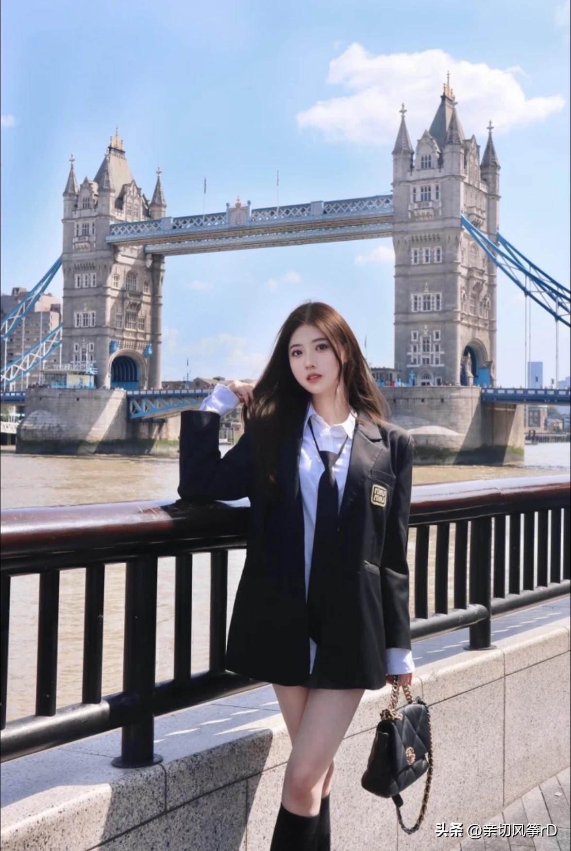 在伦敦塔桥前，一位身着黑西装的少女站在那里，时尚与历史就这么奇妙地交融了。就像沈