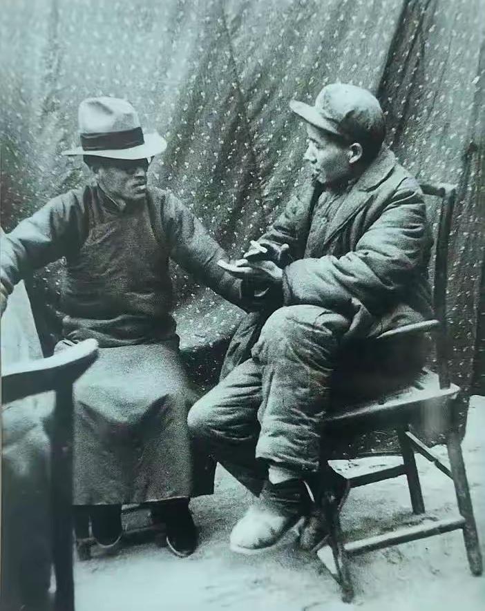 毛主席和谁呢？
照片里的毛主席，潇洒自信的如一个乡村长者，正在和那位戴着礼帽、穿