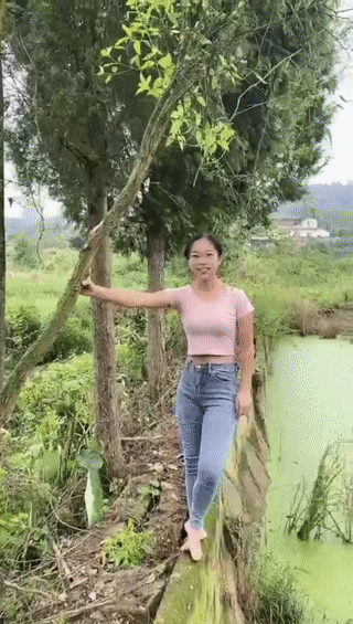 一名年轻女子在水塘边表演爬树？
结果她表演失误，最后竟然不小心撞到了自己的腰！