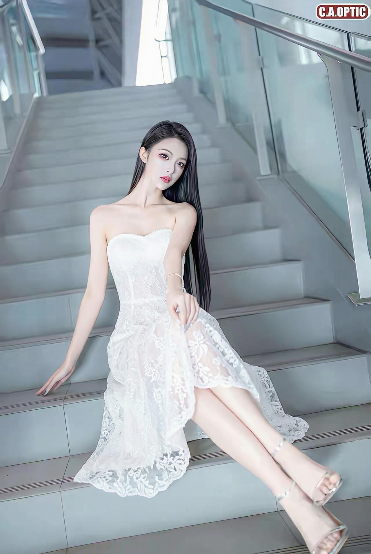 她拥有一头乌黑如瀑的长直发，垂顺地披在身后，衬得肌肤胜雪。五官精致冷艳，眉眼间带