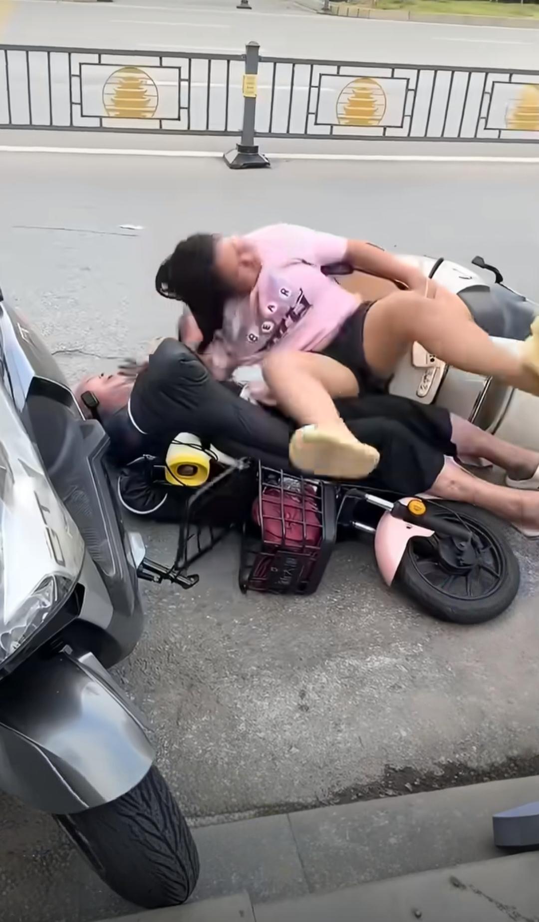 街头实拍！两名骑电动车的人相撞倒地后，其中一名男子死死的抓住另外一名女子的头发，