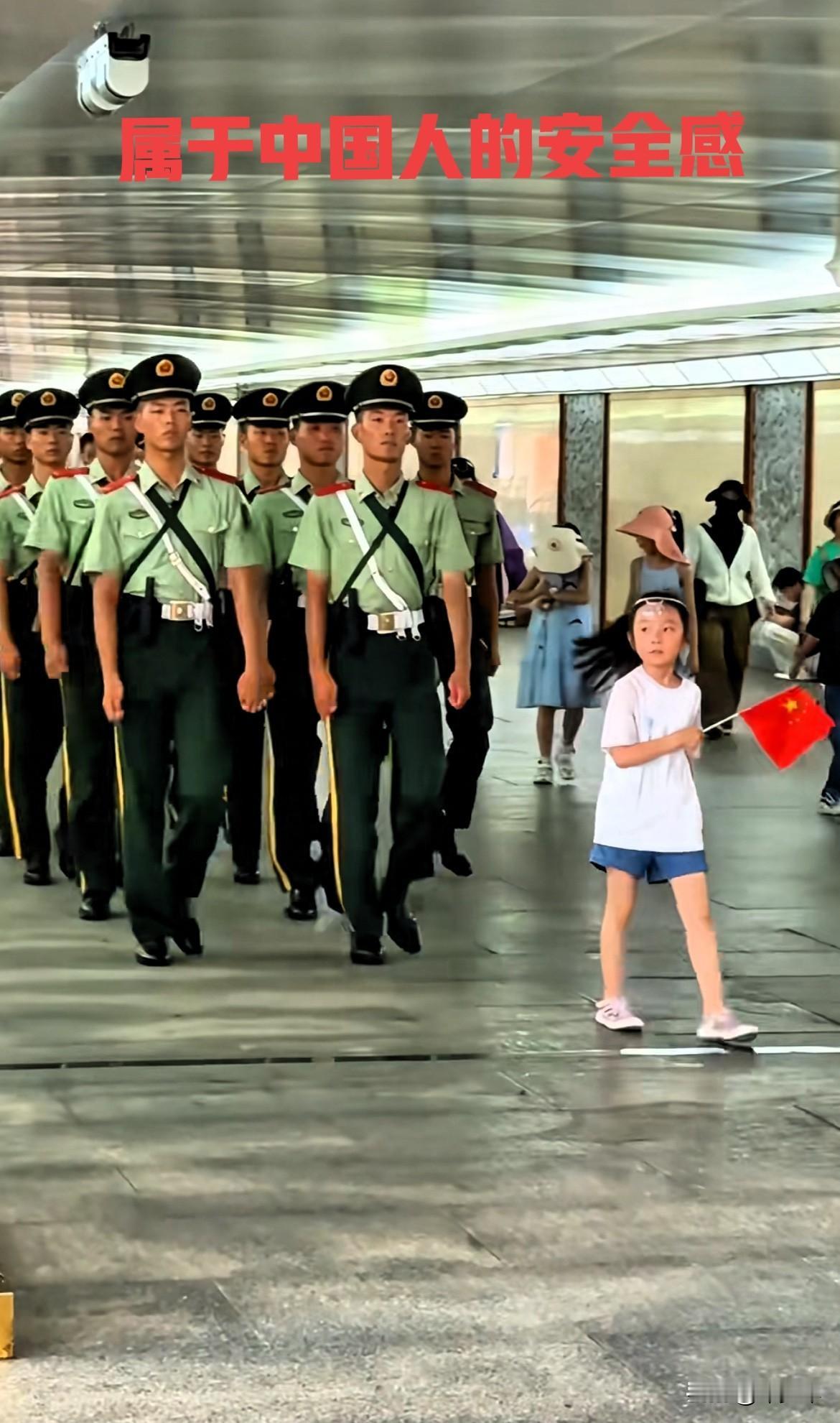 一位小女孩挥舞着国旗走在刚结束任务的武警队伍前面，这是独属于中国人的安全感！