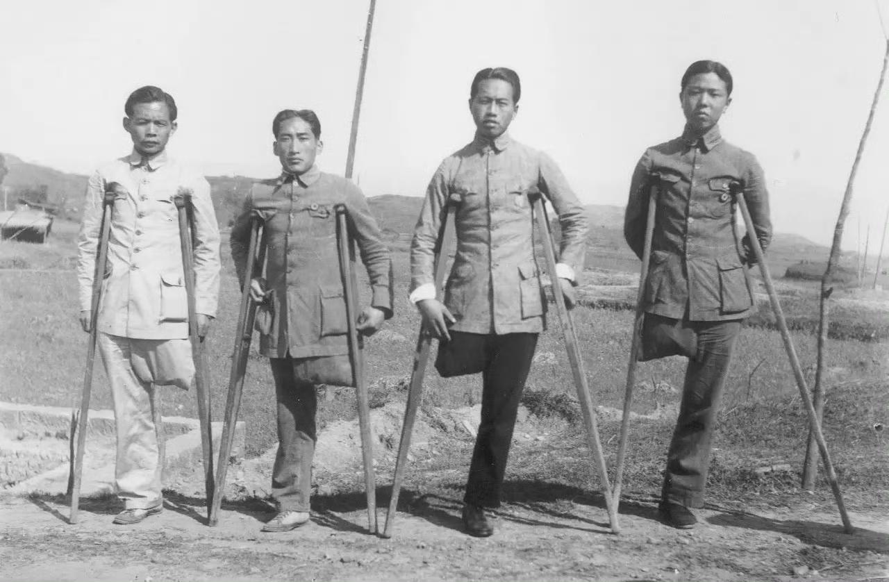 照片中四个拄拐的男人是李家雄、葛仁祥、任成玉、曾炳山，他们是个顶个的大英雄，在1