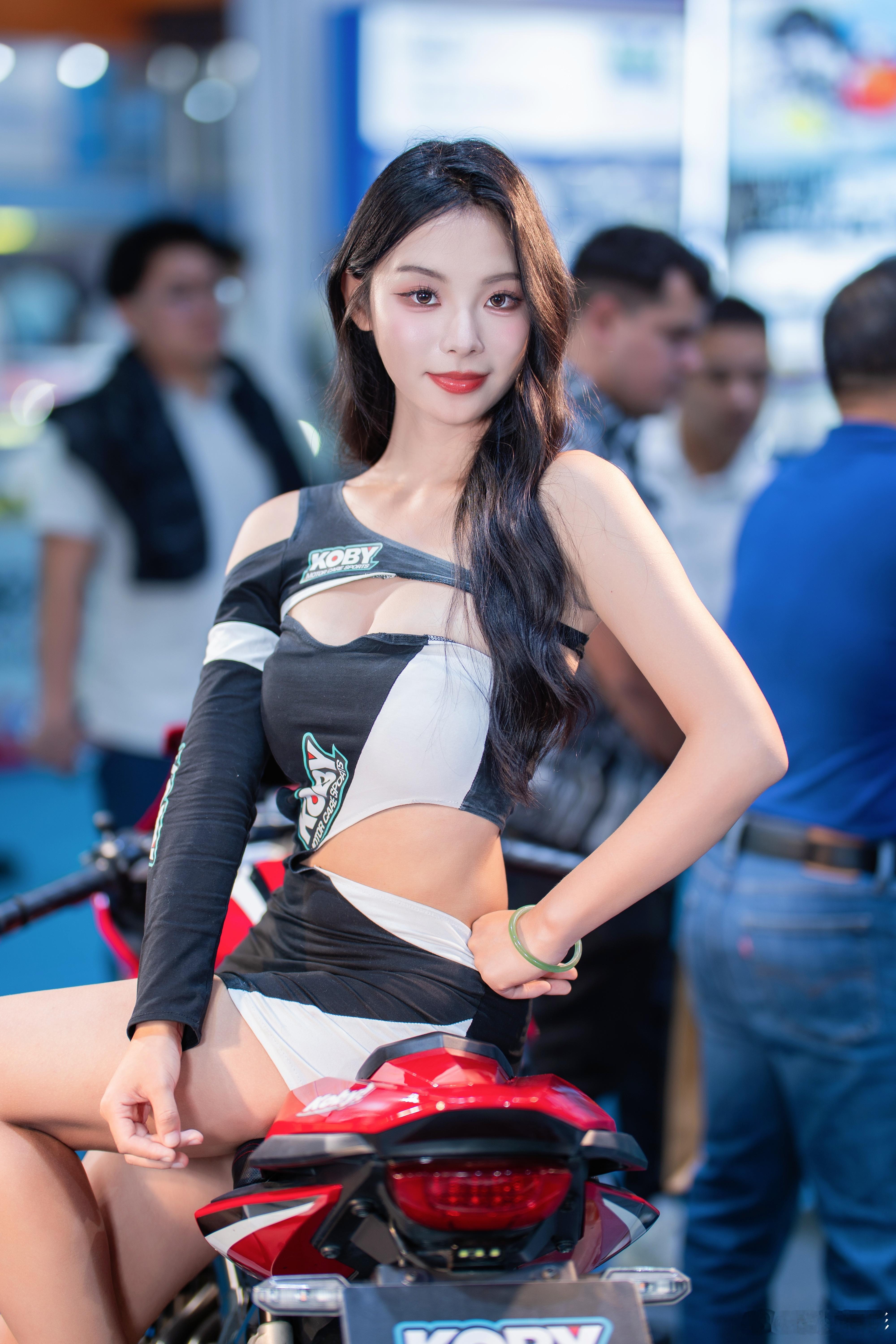 对面的女孩看过来，坐在摩托车上的小姐姐模特：未闻芳名活动：广州摩配展   