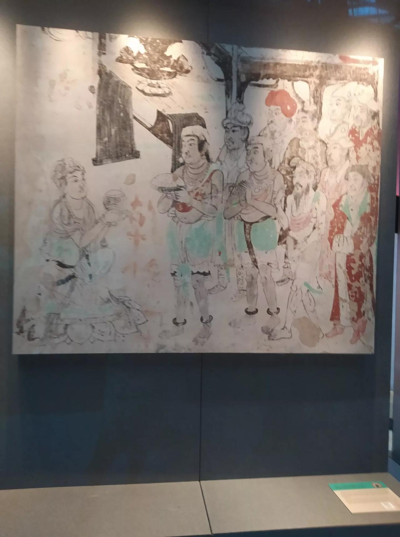我在敦煌展上拍的相片，这幅画应该是佛经故事，释迦牟尼佛在乞食。但这站着的人又是谁