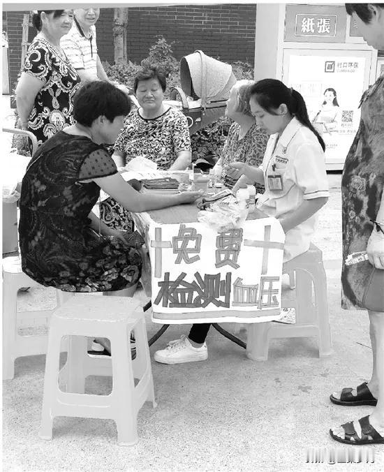 一条街上有三个药店，门口都摆放一张桌子，桌子上都放了测量血压的仪器，旁边坐着一个