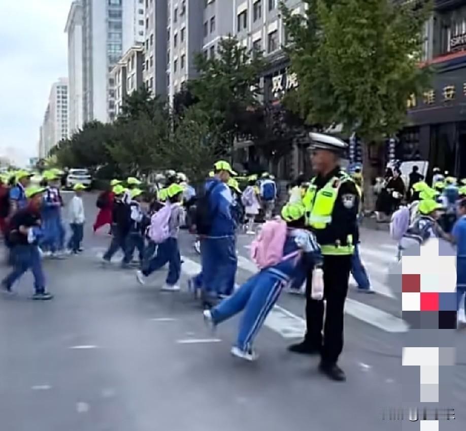 近日，甘肃天水，小学生通过斑马线时，看到熟悉的执勤交警，纷纷飞奔向执勤交警求抱抱