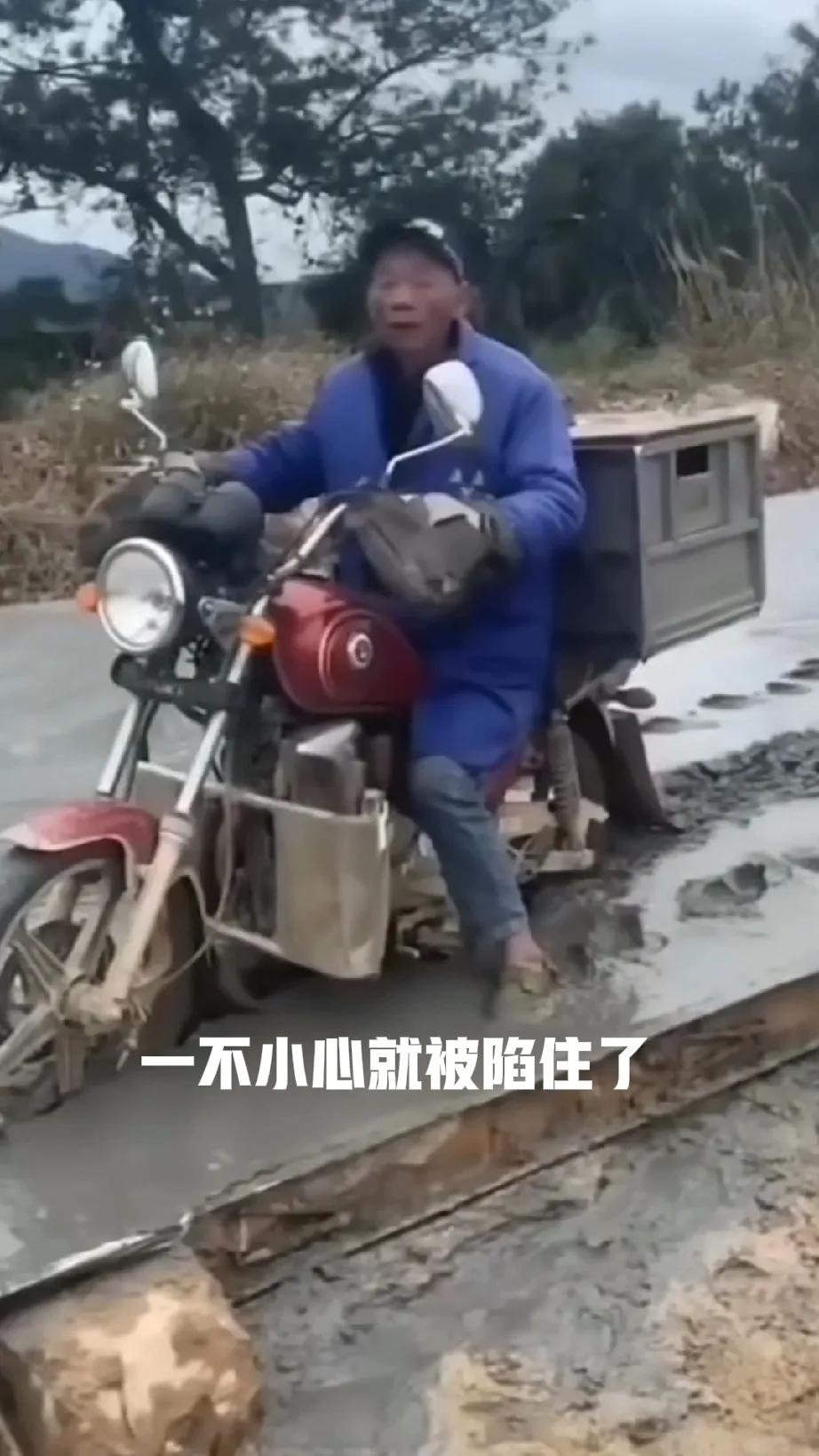 一位大爷开着三轮车，一不小心就驶上了刚修的水泥路竟然卡在了上面，半天动不了。
有