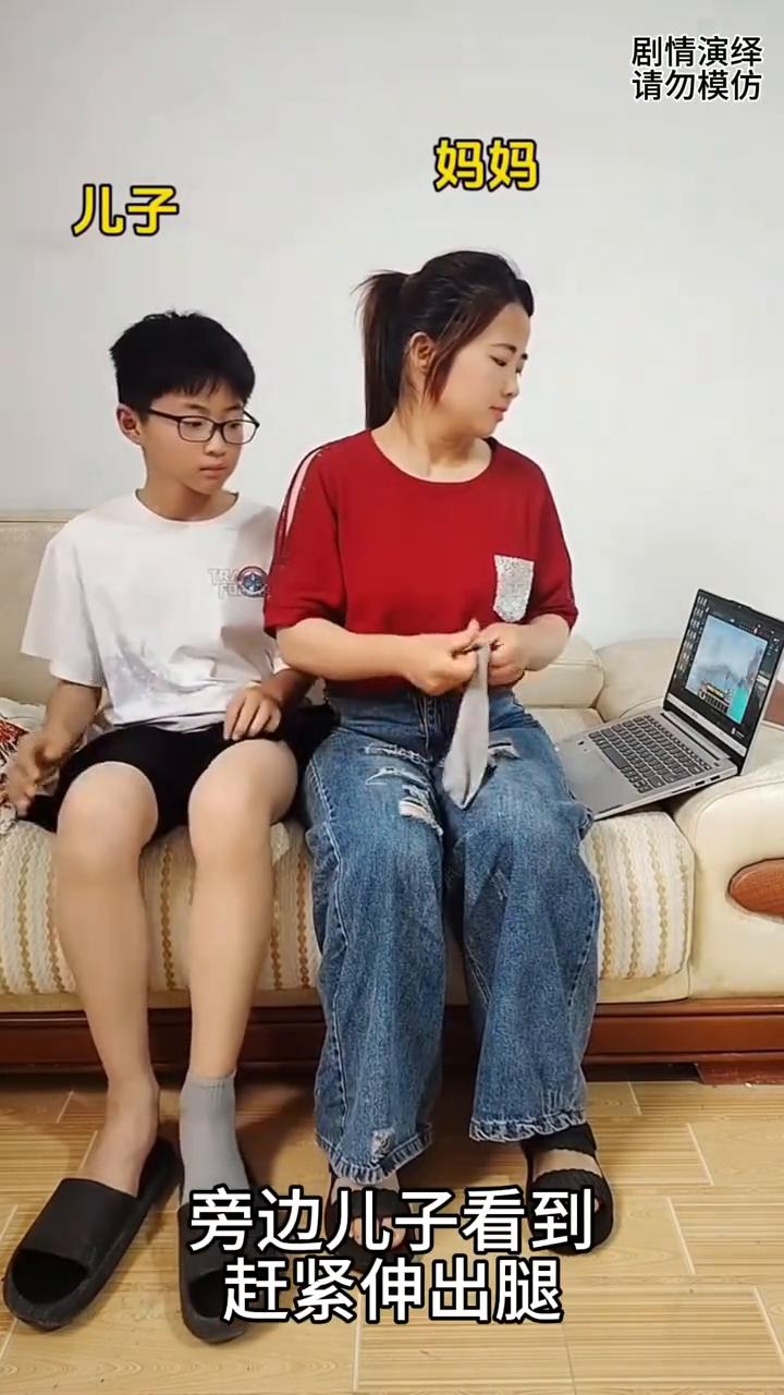 妈妈看电视剧太入迷了，谁知她将袜子穿到儿子脚上了。
妈妈正在看电视剧时，接着她拿