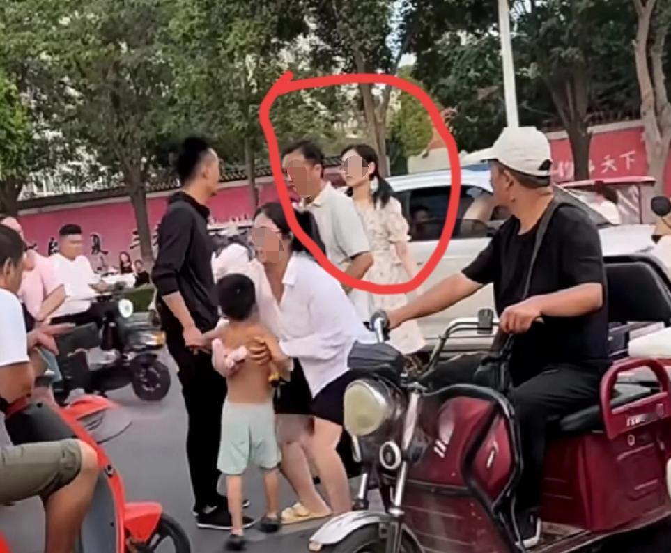 人行道上，小朋友光着膀子，跟妈妈过马路，路过的小仙女不乐意了。用手指着小朋友妈妈