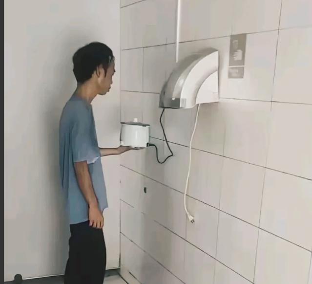 “现在的年轻人真不容易啊”！一小伙趁着公厕里没有人，把电饭锅带进去煮饭，保洁无意