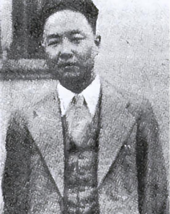 他戴着黑框眼镜，穿着军装，腰间挂着指挥刀，脚蹬皮靴，在几个随从的簇拥下，趾高气扬