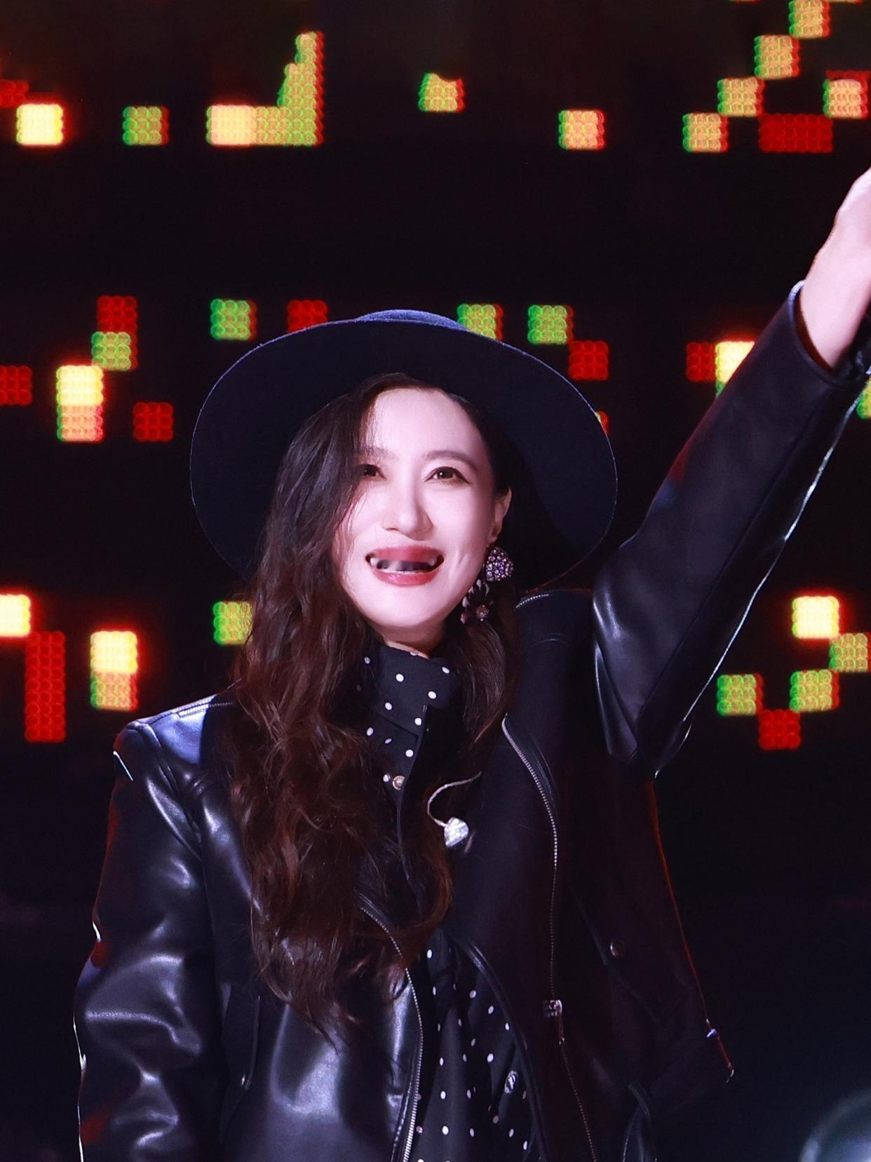 谭晶舞台上的全黑皮衣套装自带气场——亮面皮质裹出利落线条，内搭波点丝巾又添了丝复