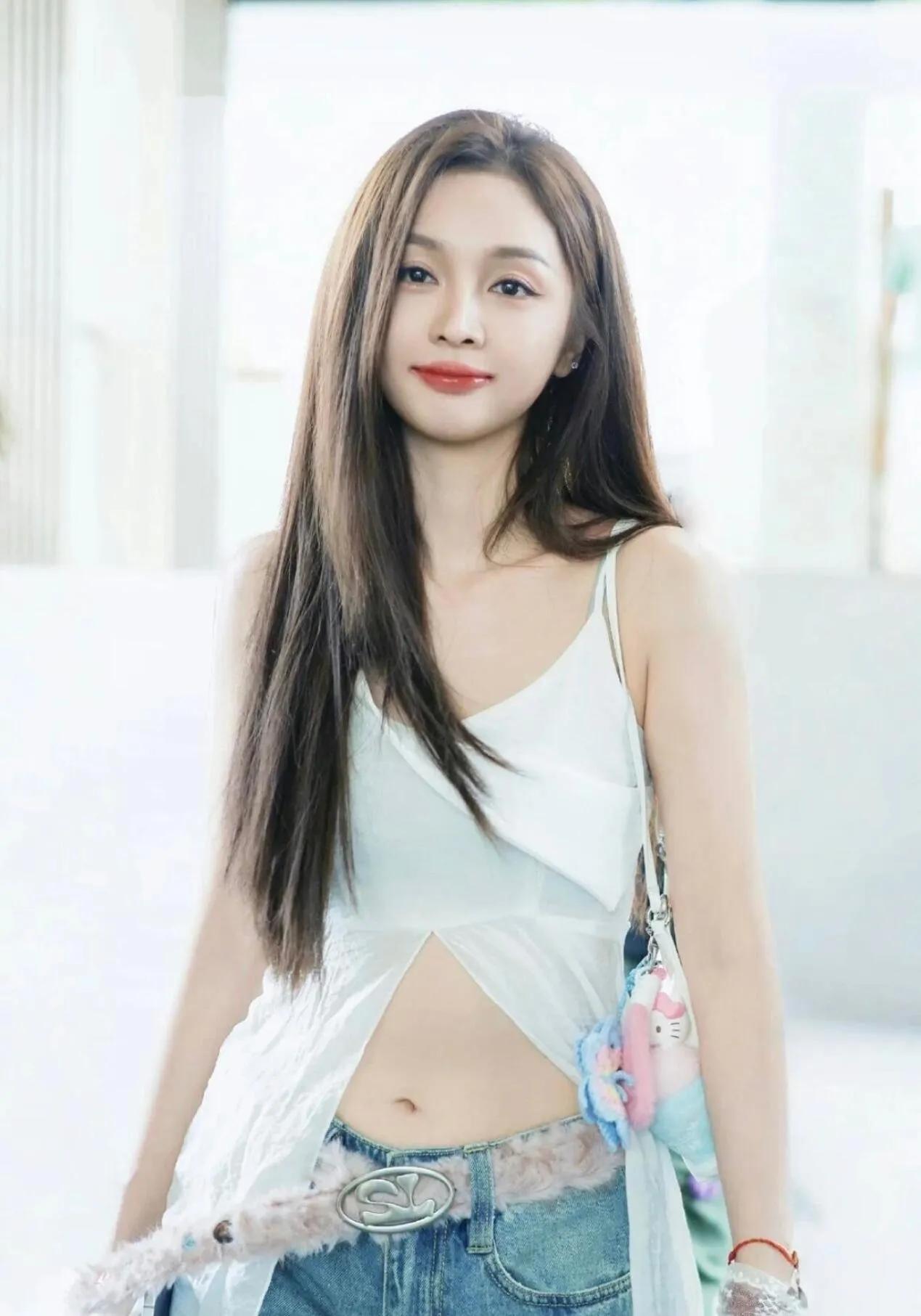 吴宣仪不愧是甜辣风的天花板！
这件开叉白吊带+浅蓝牛仔裤，上短下长的搭配直接把身