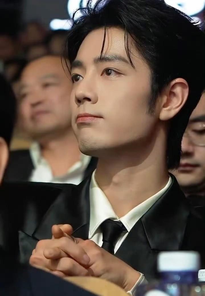 刷到一条视频，是肖战在片场休息。
他在那儿翻着一本挺厚的书，旁边人走来走去收拾器