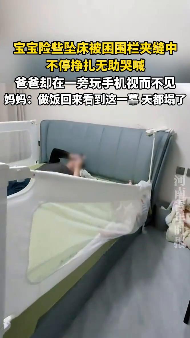 宝宝险些坠床被困围栏夹缝中，不停挣扎无助哭喊，爸爸却在一旁玩手机视而不见。妈妈：