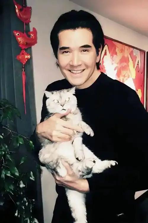 2026年4月浙江金华的美食街上，66岁的费翔身着浅色西装，正笑着品尝地方小吃，